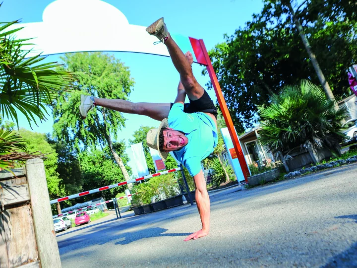 Personne faisant un équilibre à une main dehors.