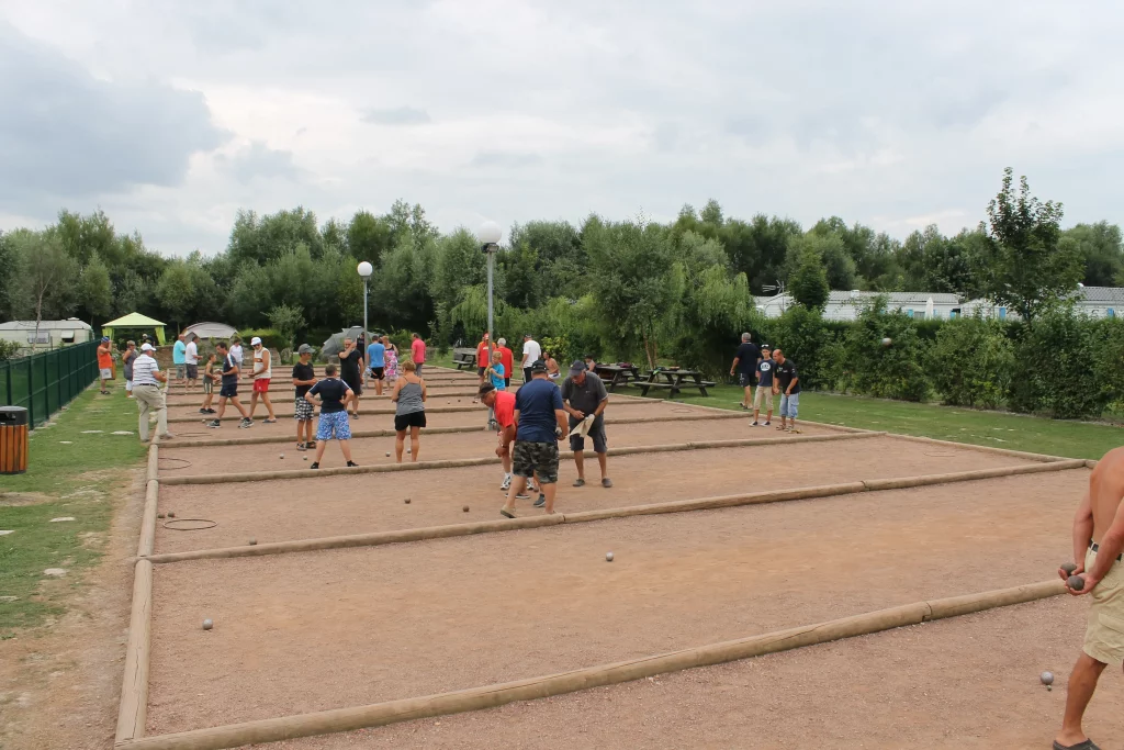Partie de pétanque animée entre vacanciers au camping des Roses