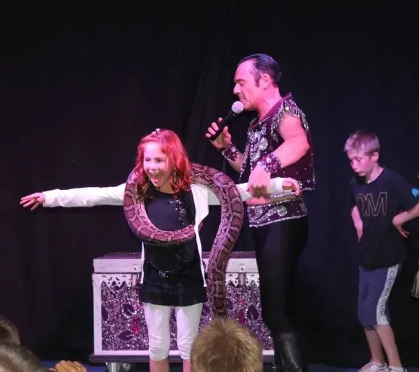 Magic show with snake on stage.