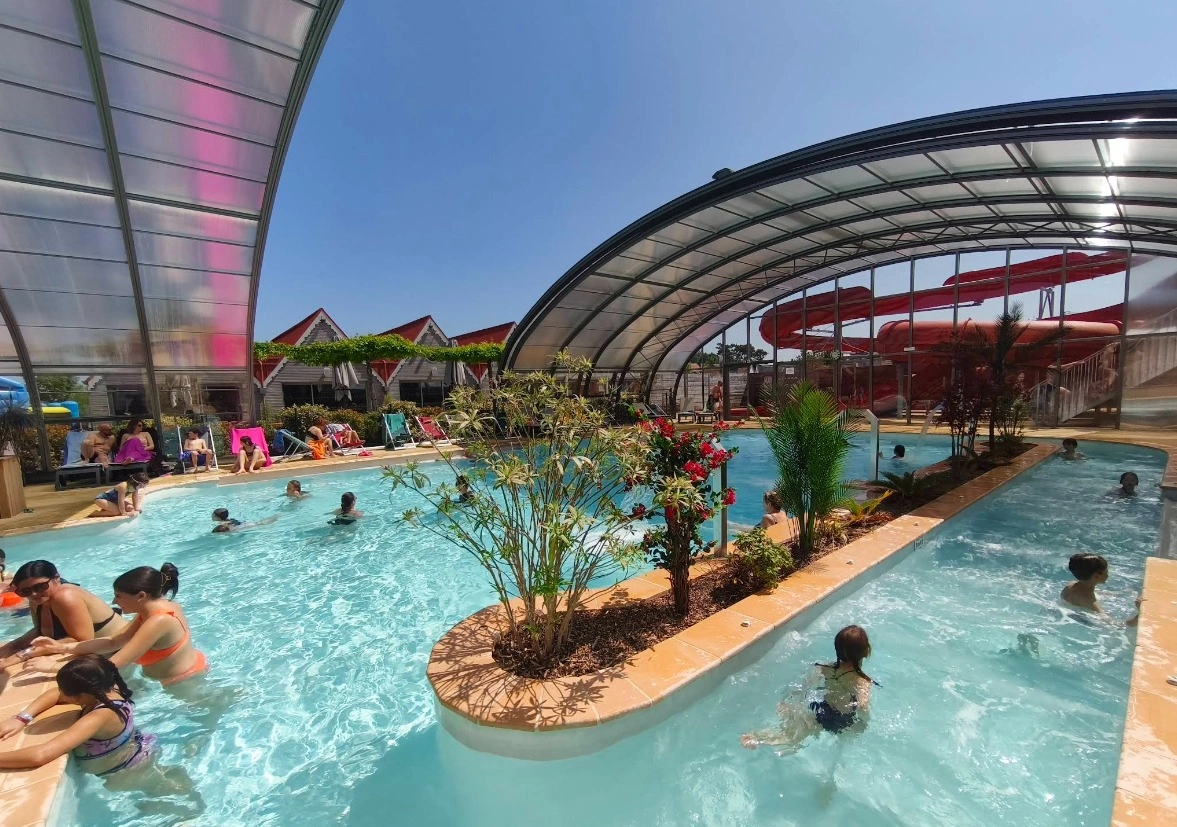 Piscine animée avec toboggan et plantes.