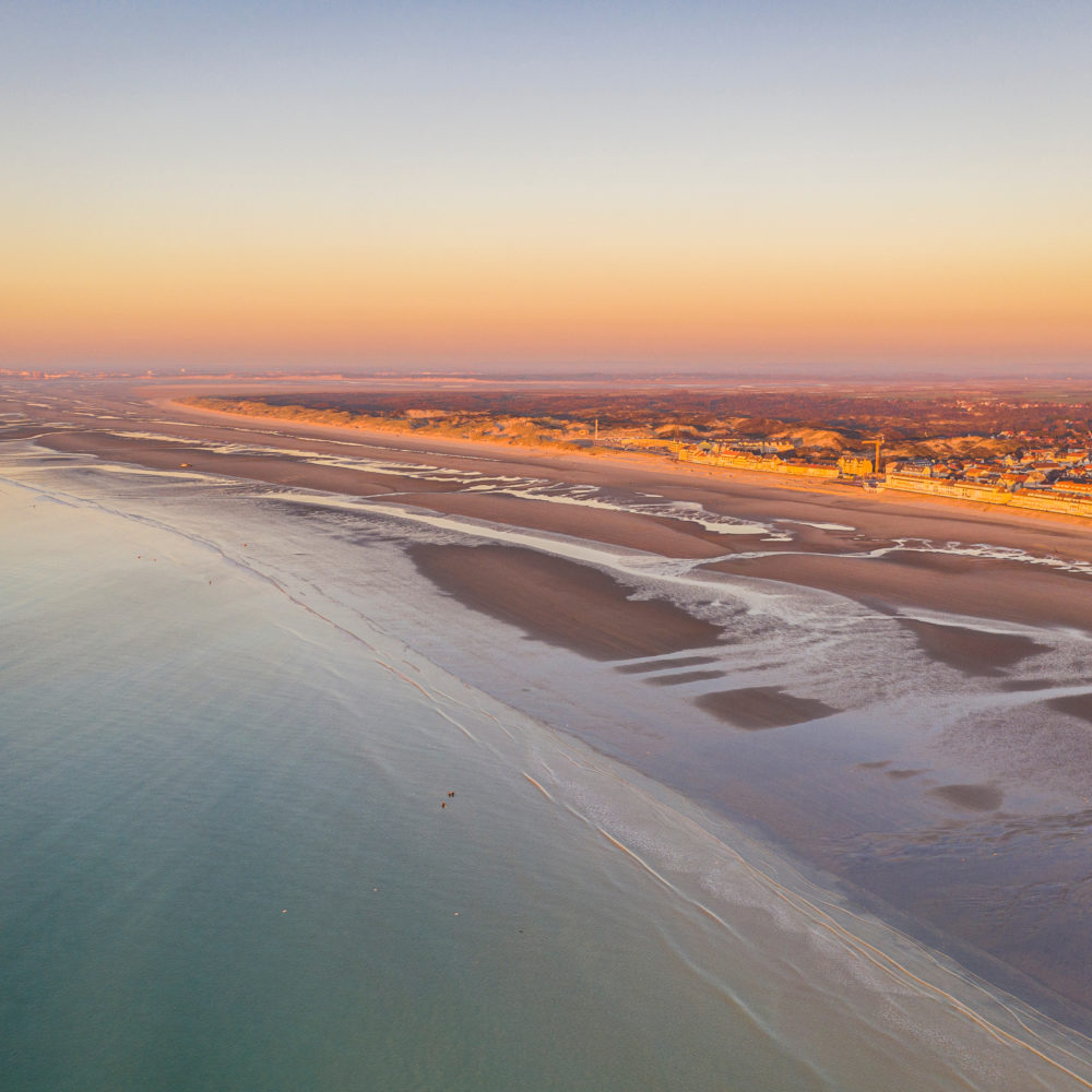 Vue aérienne d'une plage au coucher de soleil.