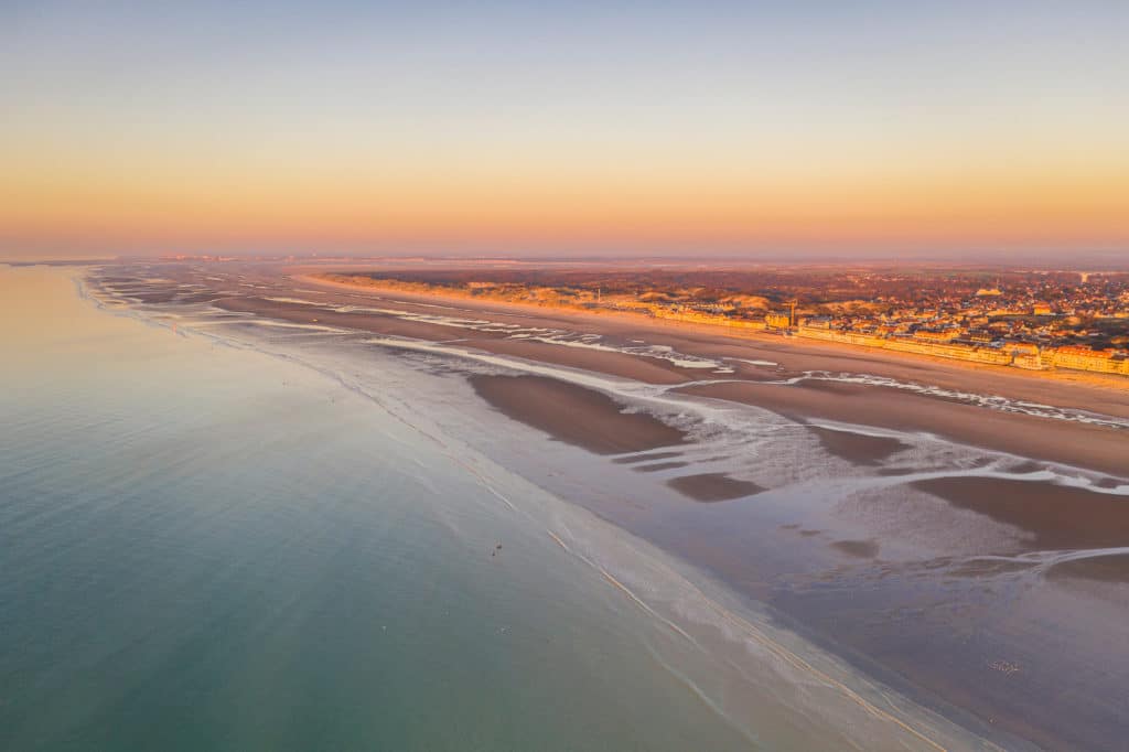 Vue aérienne d'une plage au coucher de soleil.
