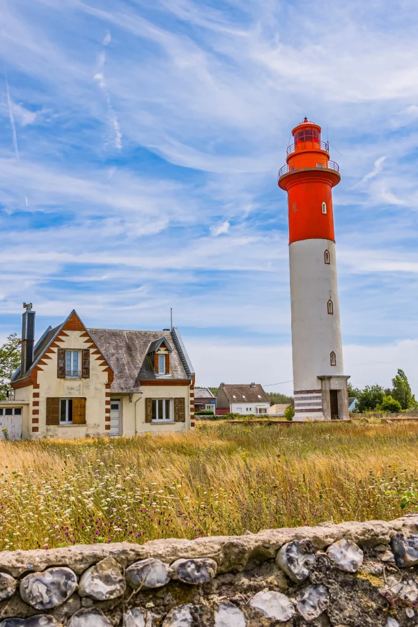 Phare et maison sous ciel nuageux