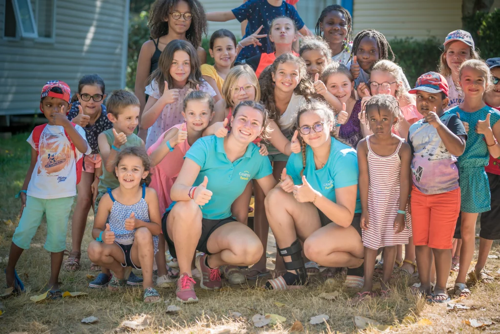 Groupe d'enfants souriants en plein air.