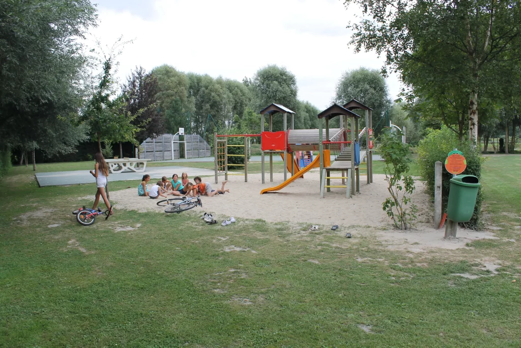 Enfants jouant dans un parc avec toboggan.
