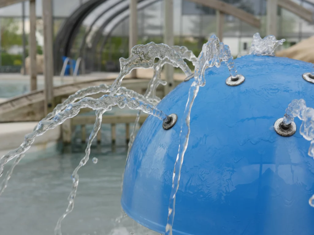 Jets d'eau sur dôme bleu dans piscine.