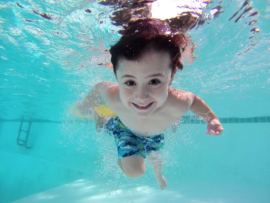 Enfant sous l'eau dans une piscine.