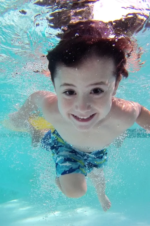Enfant sous l'eau dans une piscine.