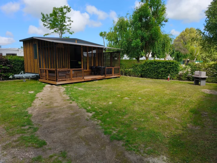 Chalet en bois entouré de verdure.
