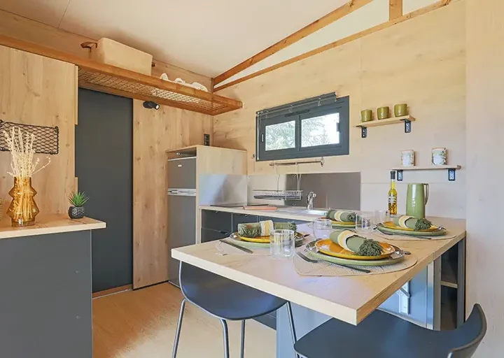 Cuisine moderne avec table dressée et vaisselle.