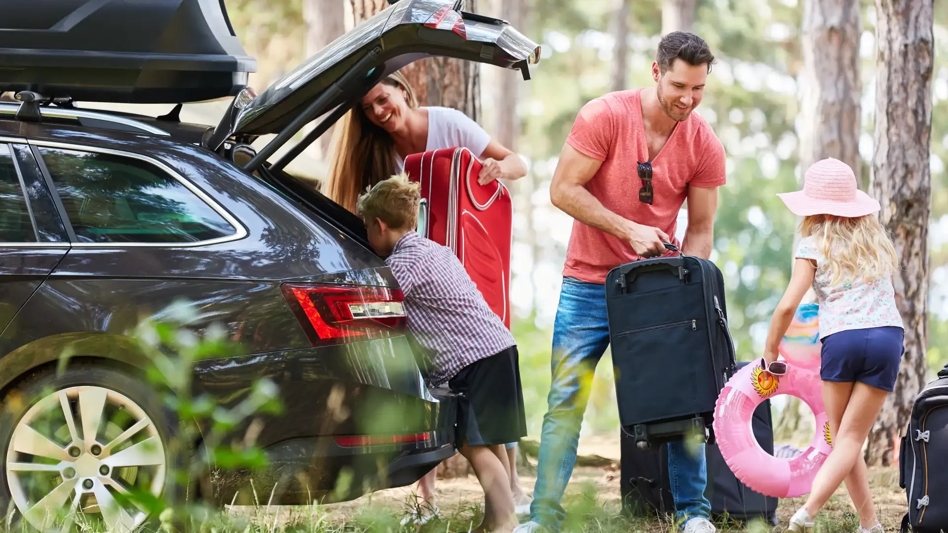 Famille chargeant une voiture pour les vacances.