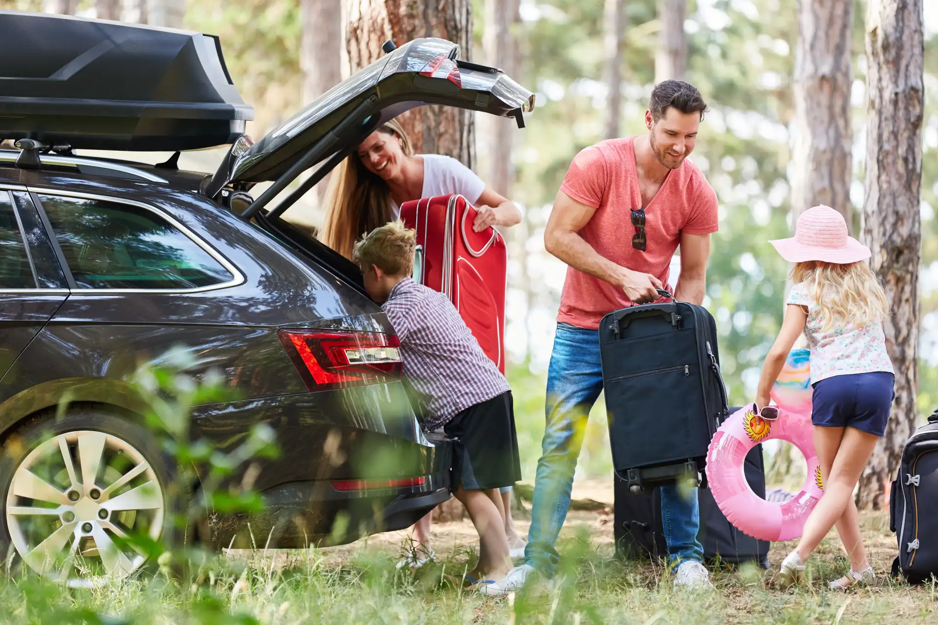Famille chargeant une voiture pour les vacances.