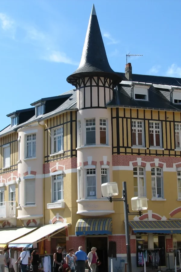 Maison à colombages avec tour et boutiques.