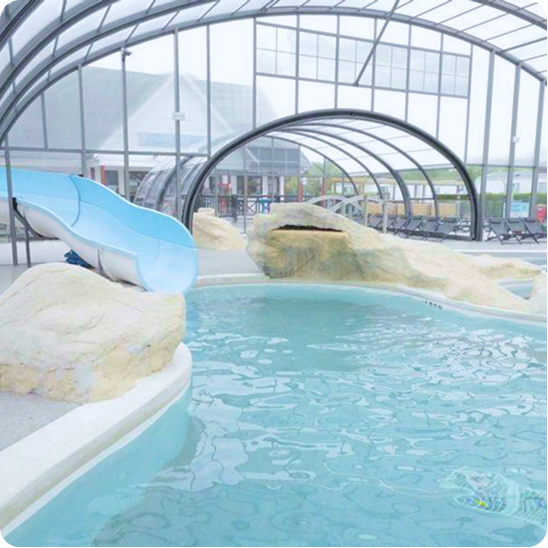 Piscine intérieure avec toboggan aquatique.