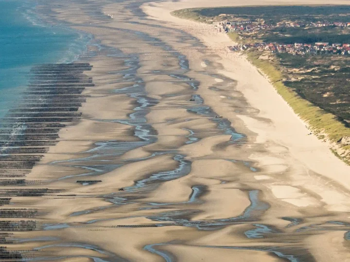 Vue aérienne d'une plage avec des dunes de sable.