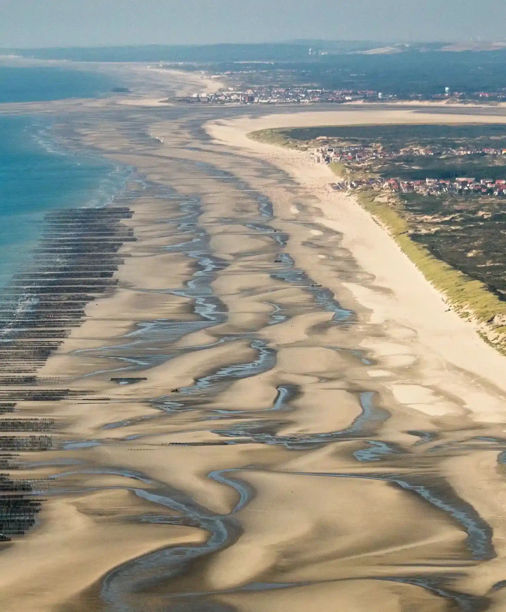 Vue aérienne d'une plage avec des dunes de sable.