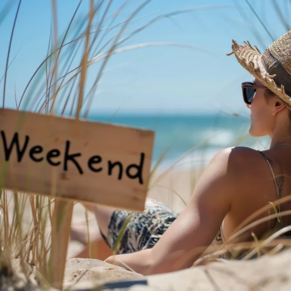 Femme se détendant sur la plage, panneau 'Weekend'