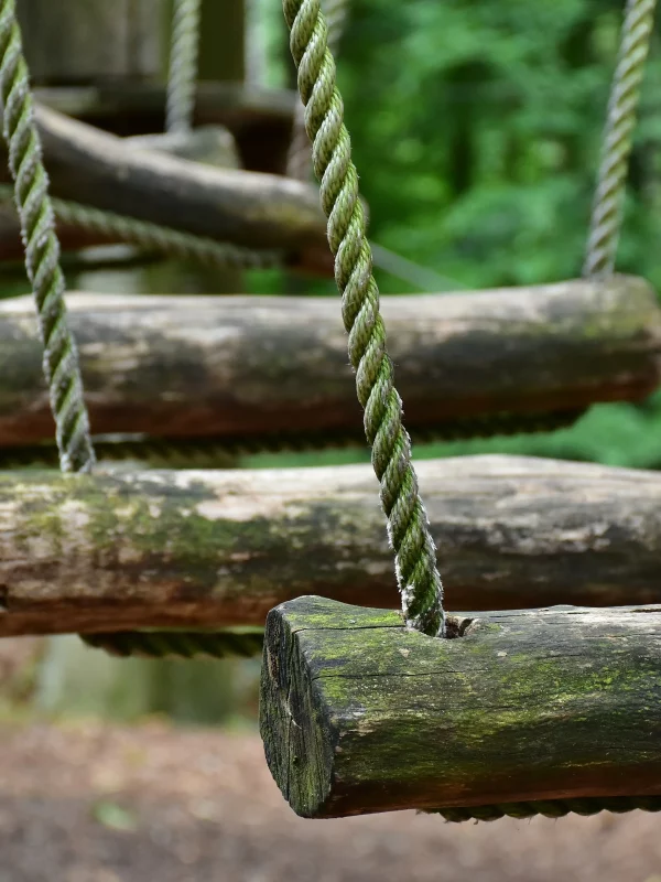 Barres en bois suspendues dans une aire de jeux.