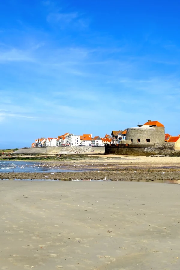 Plage avec bâtiments et ciel bleu dégagé.