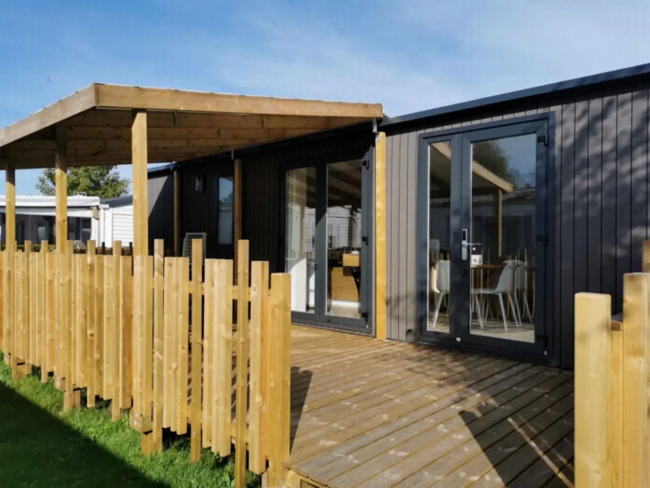 Maison moderne avec terrasse et clôture en bois.